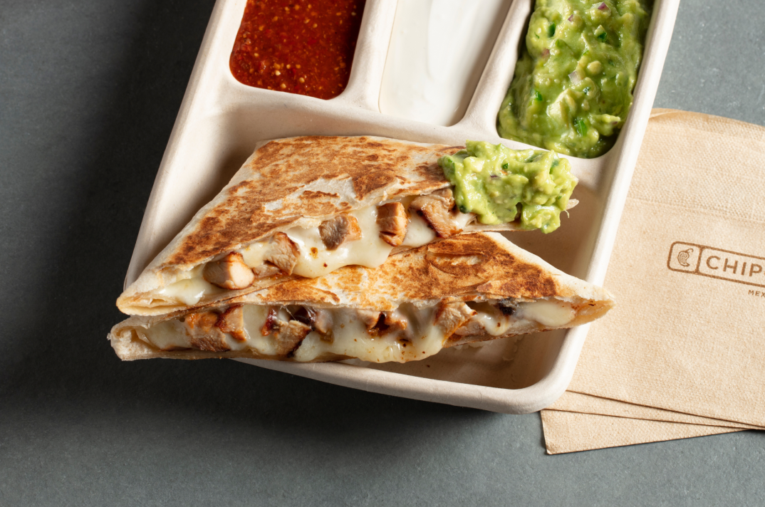 A Chicken Quesadilla from Chipotle with a side of fresh made Guac, Sour Cream, and Tomatilla-Red Chili Salsa.